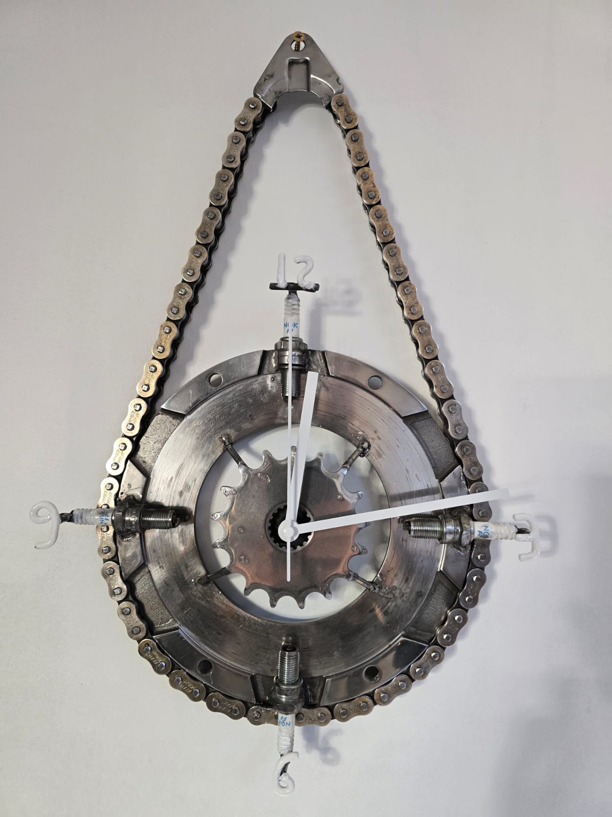 Horloge murale en goutte, chaîne de moto et bougies aux heures